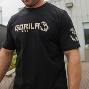 Man wearing a black 'Gorilla Fitness' t-shirt outdoors.