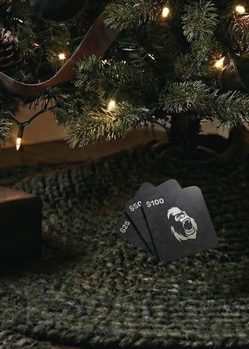 Three Gorila Fitness Canadian digital gift black cards with white text and a logo under a decorated Christmas tree.