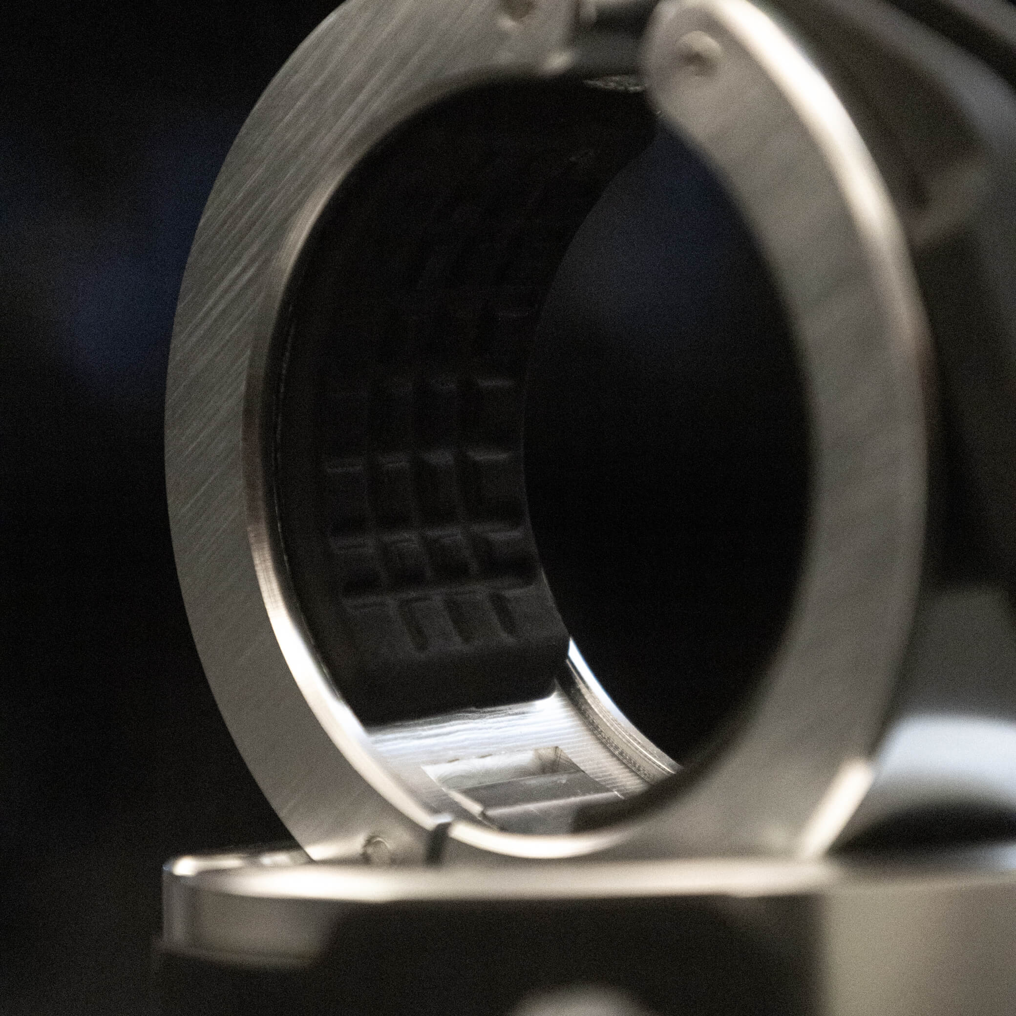 Extreme close-up of a Gorila Aluminium Barbell Collar showing the precision-machined aluminum interior and the textured rubber grip pattern inside the clamp, designed for maximum hold on Olympic barbells under heavy load.