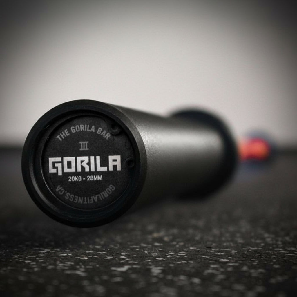 Endcap logo view of Gorila Bar Red Teflon Olympic barbell – precision-machined steel sleeves, 190K PSI tensile strength, and advanced PTFE coating alternative to Cerakote