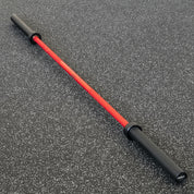 Gorila Bar Red Teflon Olympic barbell on black gym floor – premium red shaft and black sleeve finish offering Cerakote-like protection with vibrant color and high tensile steel performance
