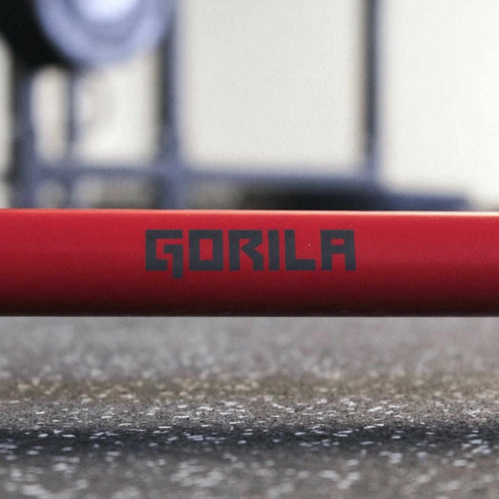 Close-up of Gorila Bar Red Teflon shaft logo – high-res view of red PTFE coating comparable to Cerakote barbells, highlighting dust-resistant surface and premium craftsmanship