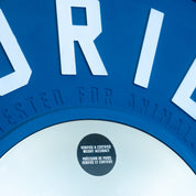 Close-up of debossed TESTED FOR ANIMALS logo on edge of a competition plate and Verified & Certified Weight Accuracy sticker