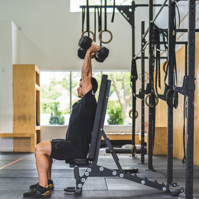 Athlete performing seated dumbbell shoulder press on Gorila Fitness adjustable incline bench, heavy-duty Canadian-made gym equipment