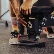 Close-up of athlete adjusting the Gorila Fitness adjustable bench using the front handle, showing heavy-duty steel construction made in Canada