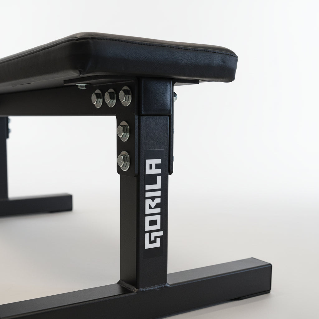 Side view of Gorila Fitness flat bench in a gym environment, built for professional strength training and durability.