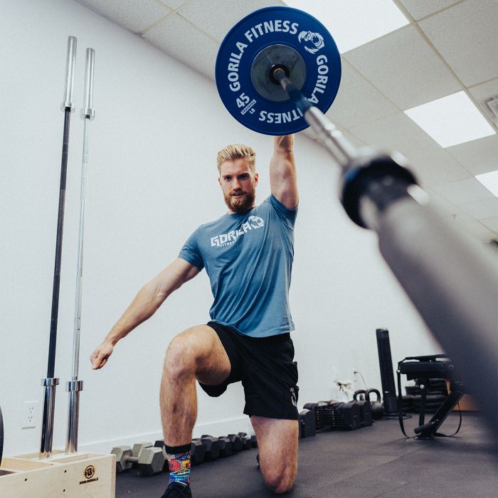 Athlete performing barbell landmine shoulder press in lunge position with Gorila Fitness Landmine attachment, demonstrating versatility and functional strength.