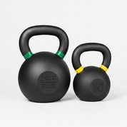 Two rubber-coated black kettlebells on a clean white background, one 24kg (53lb) and one 16kg (35lb), with green and yellow accents on the handles.