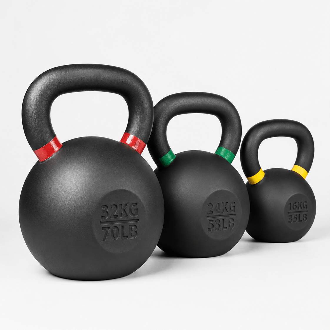 Three black kettlebells in graduated sizes with red, green, and yellow handle accents, arranged from largest to smallest on a light gray background.