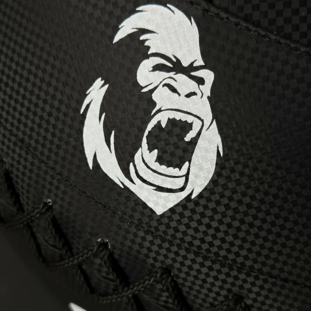 Close-up of the Gorila Fitness logo on the Medicine Ball 2.0 carbon-textured PVC surface showing high-friction weave pattern for superior grip.