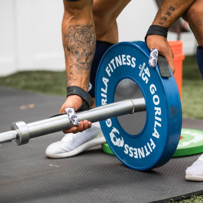 Athlete loading a Gorila Men Training Bar 2.0 with competition bumper plates – premium 20kg barbell used in Olympic weightlifting, CrossFit, and functional strength training