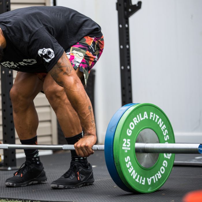 Athlete lifting with the Gorila Men Training Bar 2.0 loaded with bumper plates on lifting platform – ideal setup for clean, snatch, and jerk training sessions