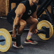 Athlete setting up for a deadlift with the Gorila Open Hex Bar 2.0 loaded with bumper plates, demonstrating ergonomic grip and open-frame lifting position.