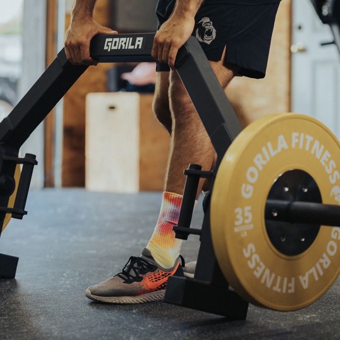 Close-up of athlete’s feet and Gorila Open Hex Bar 2.0 flipping in its loading position, highlighting precise handle alignment and stability of the integrated jack system.