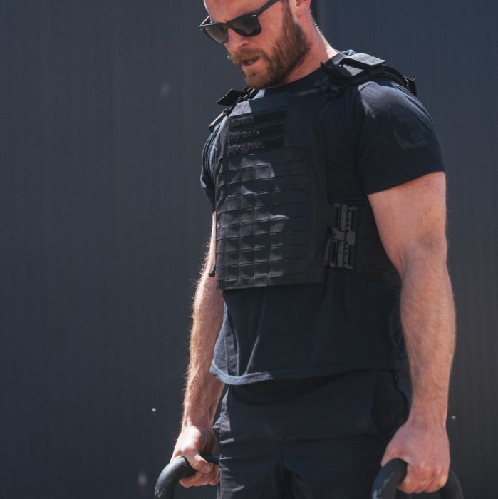 Male athlete lifting and moving in the Phantom 2.0 plate carrier, a balanced weighted vest for gym and outdoor training in Canada, farmer walk