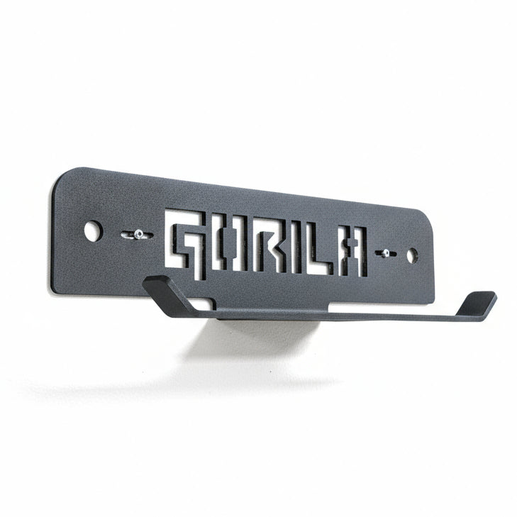 Angled view of the Gorila Plate Carrier and Rope Storage wall mount showing laser-cut steel construction, matte black finish, and multiple mounting holes for versatile installation.