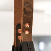Pair of Gorila tricep leather straps hanging from cable attachment, ideal for strength and bodybuilding accessory work.